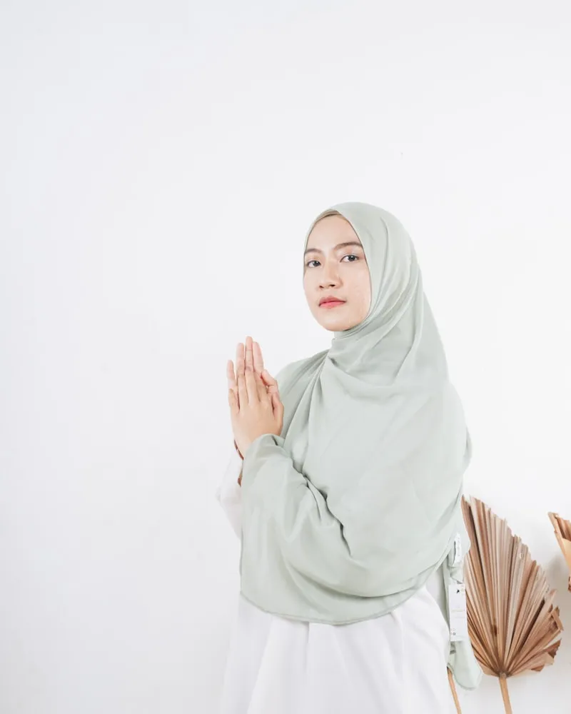 Professional studio hijab headshot with sage green hijab
